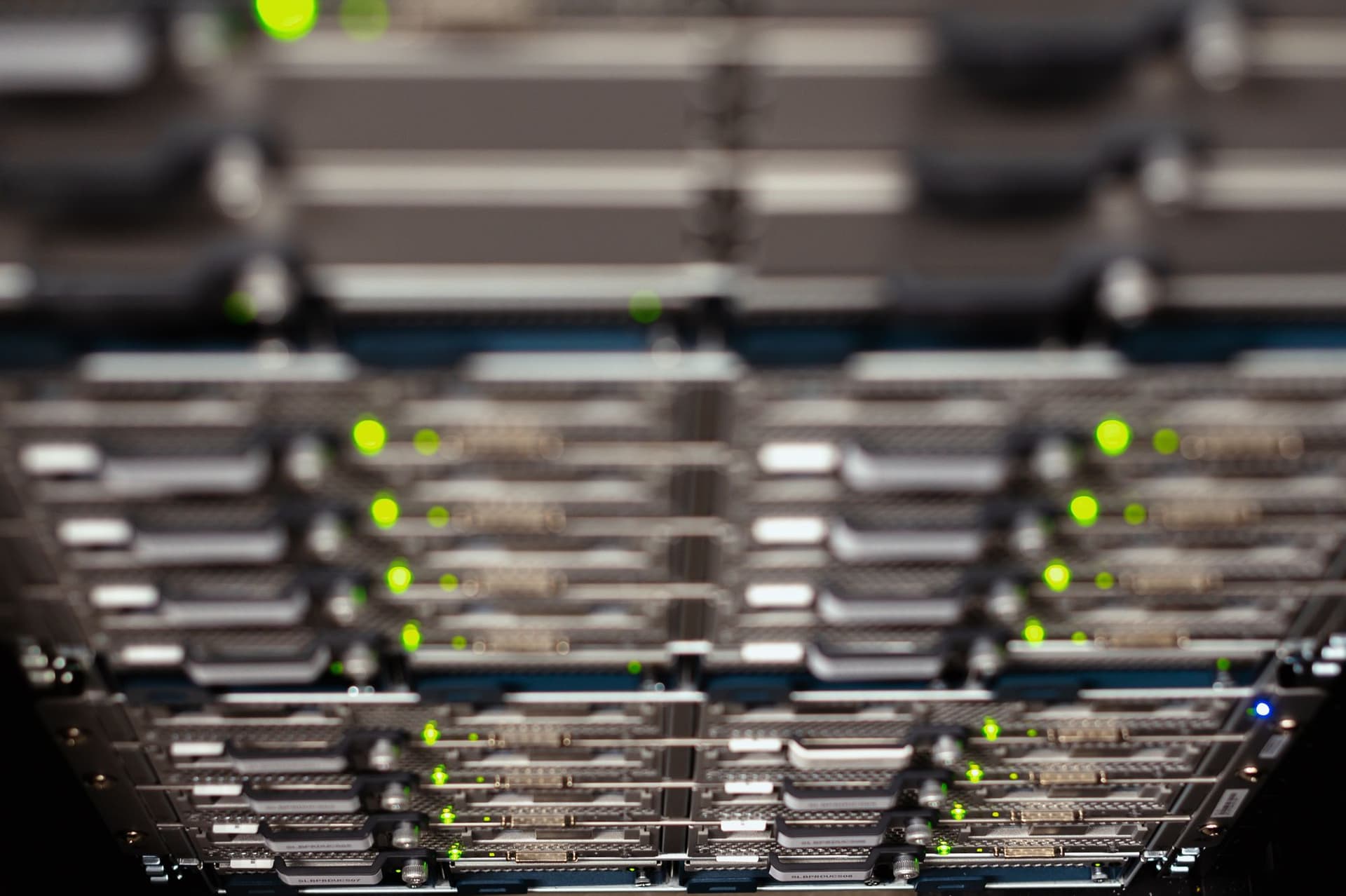 Rows of rack-mounted server drive trays with green status lights in a data center